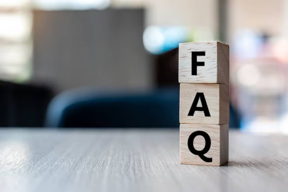Wooden blocks stacked to spell FAQ on a blurred background, emphasizing a focus on frequently asked questions.